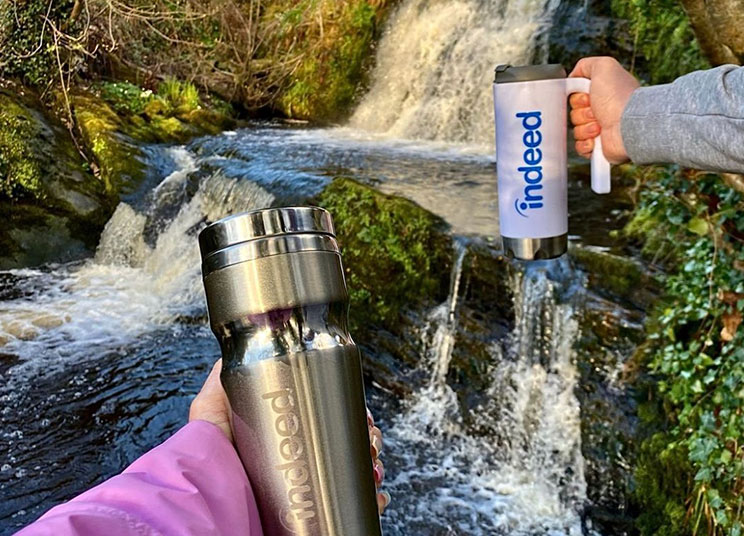 Indeed water bottles in from of a waterfall
