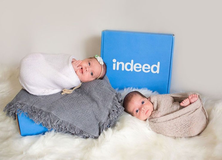 Two babies next to an Indeed box